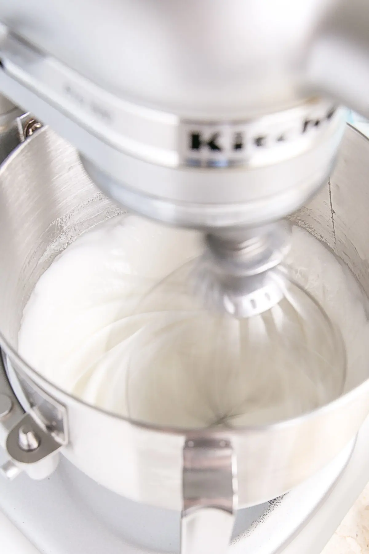 This old-fashioned 7 minute frosting recipe is light, delicious, and easy to make. A pure white frosting that's perfect for a variety of delicious desserts. | livforcake.com The meringue being whipped in the stand mixer.