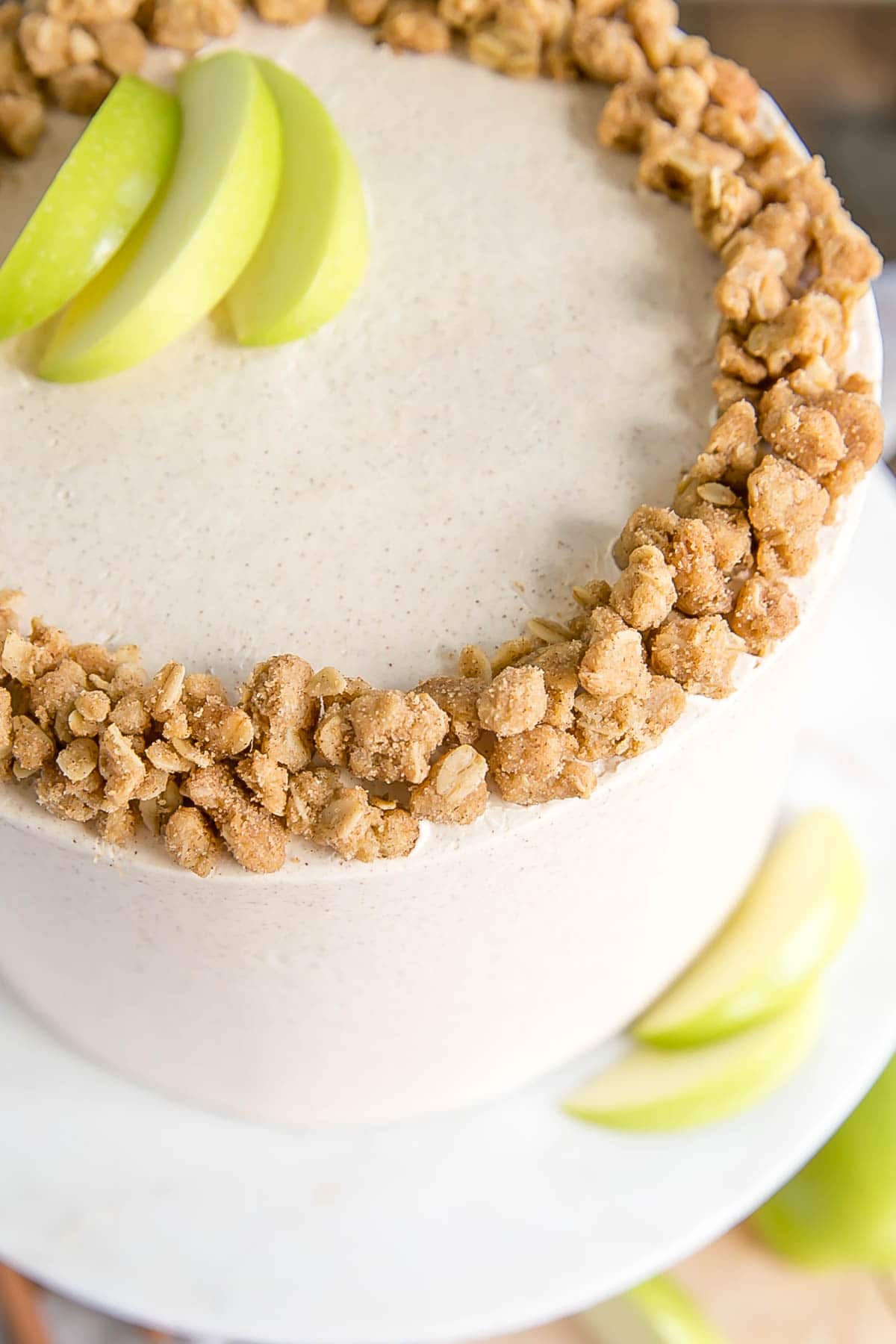 This Apple Crisp Cake pairs spice cake layers with a delicious homemade apple pie filling and apple crisp crumble. | livforcake.com Close up of apple crumble on the top of the cake.