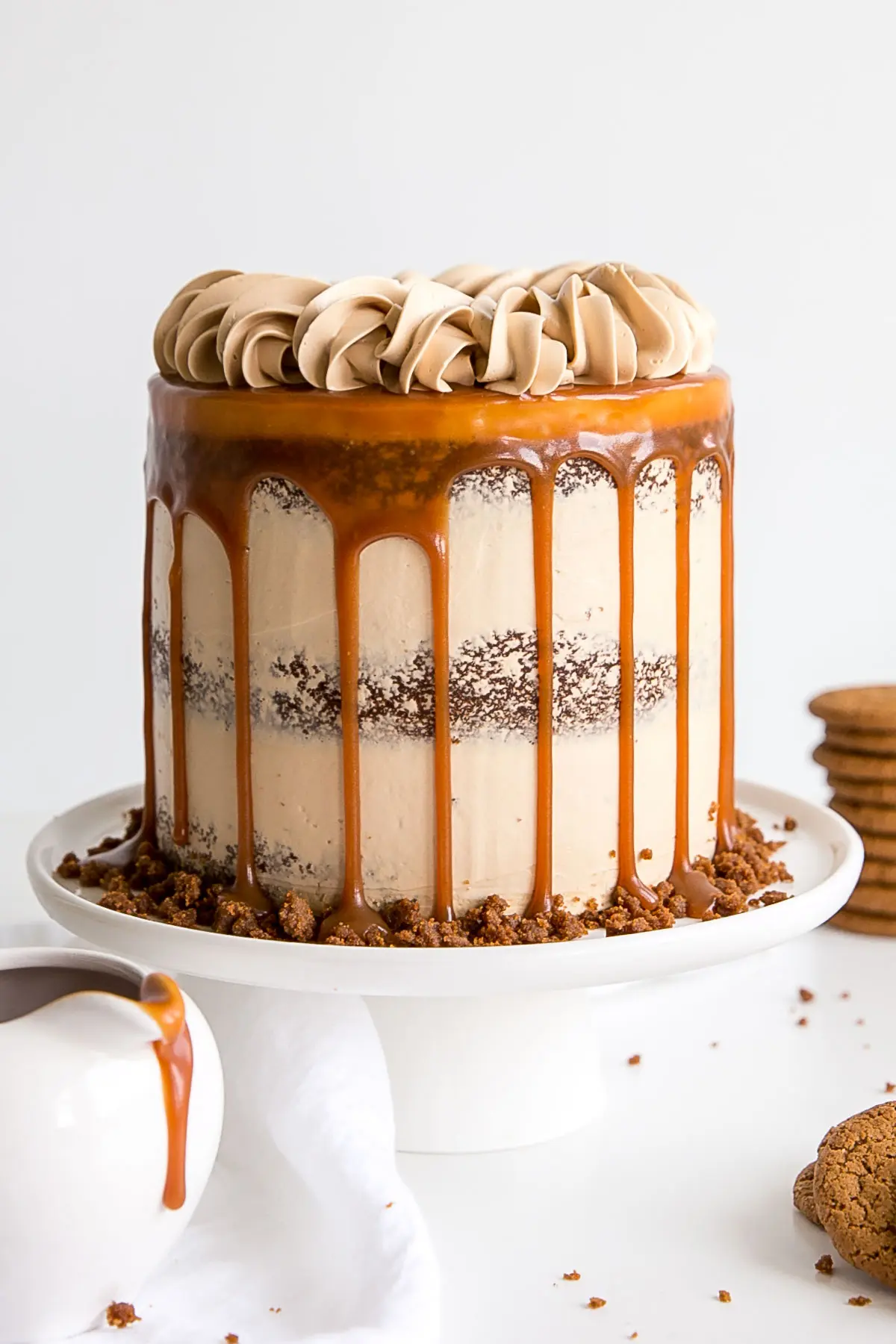 The classic Gingerbread Cake gets a delicious makeover! Gingerbread cake layers and caramel buttercream paired with gingersnap streusel and homemade caramel. | livforcake.com Gingerbread cake with caramel buttercream decorated naked cake style with a caramel drip.