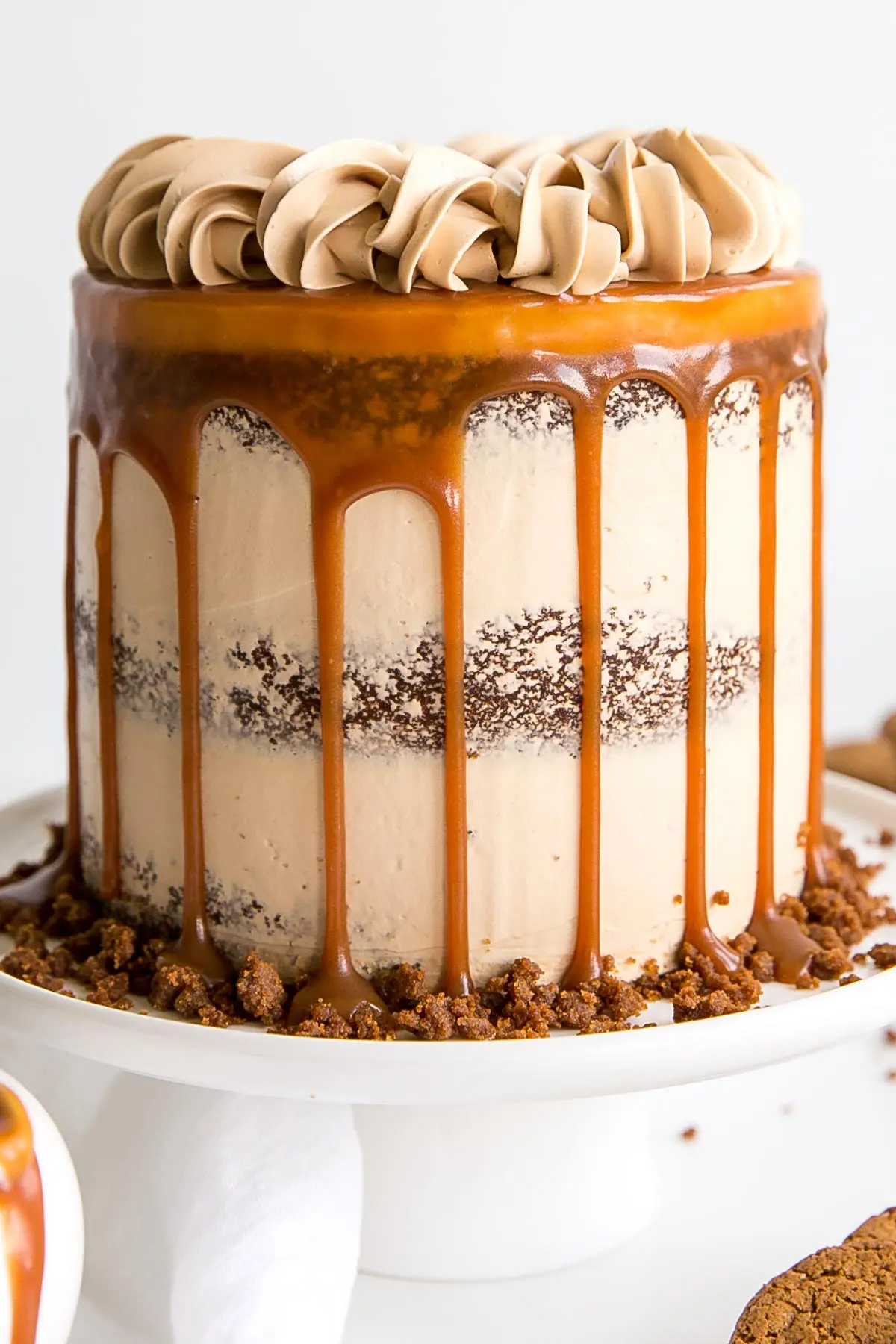 The classic Gingerbread Cake gets a delicious makeover! Gingerbread cake layers and caramel buttercream paired with gingersnap streusel and homemade caramel. | livforcake.com Close up showing caramel drip