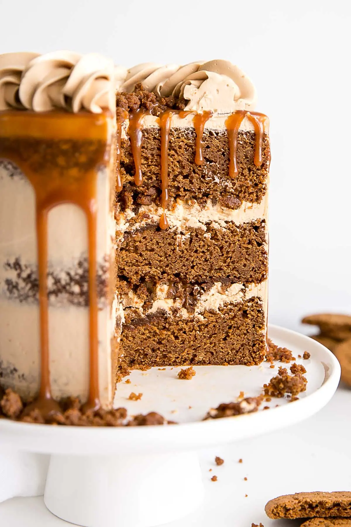The classic Gingerbread Cake gets a delicious makeover! Gingerbread cake layers and caramel buttercream paired with gingersnap streusel and homemade caramel. | livforcake.com Cross-section of a gingerbread cake with caramel Swiss meringue buttercream.