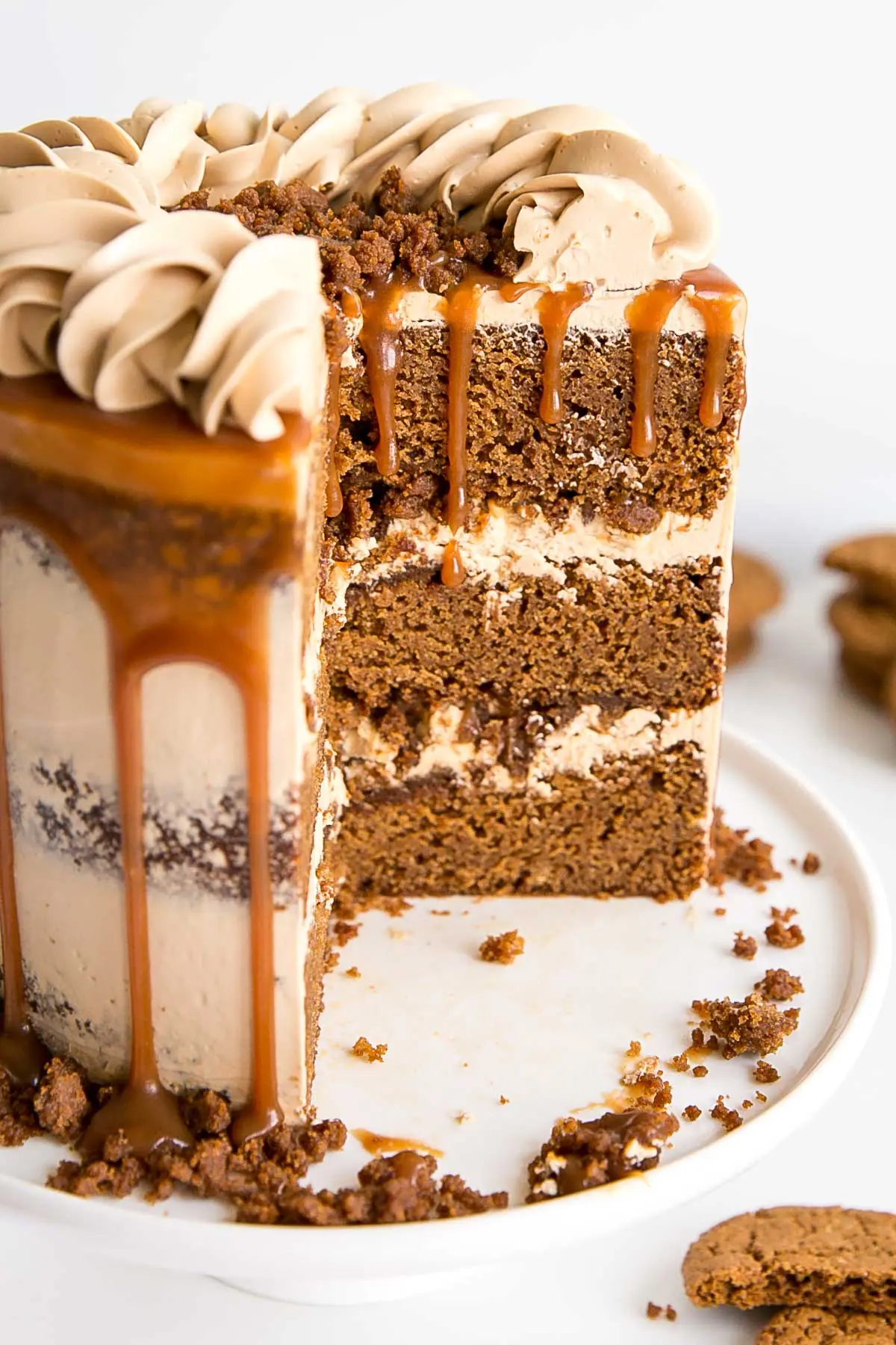 The classic Gingerbread Cake gets a delicious makeover! Gingerbread cake layers and caramel buttercream paired with gingersnap streusel and homemade caramel. | livforcake.com Cross section showing gingerbread cake layers, caramel buttercream and gingerbread streusel.
