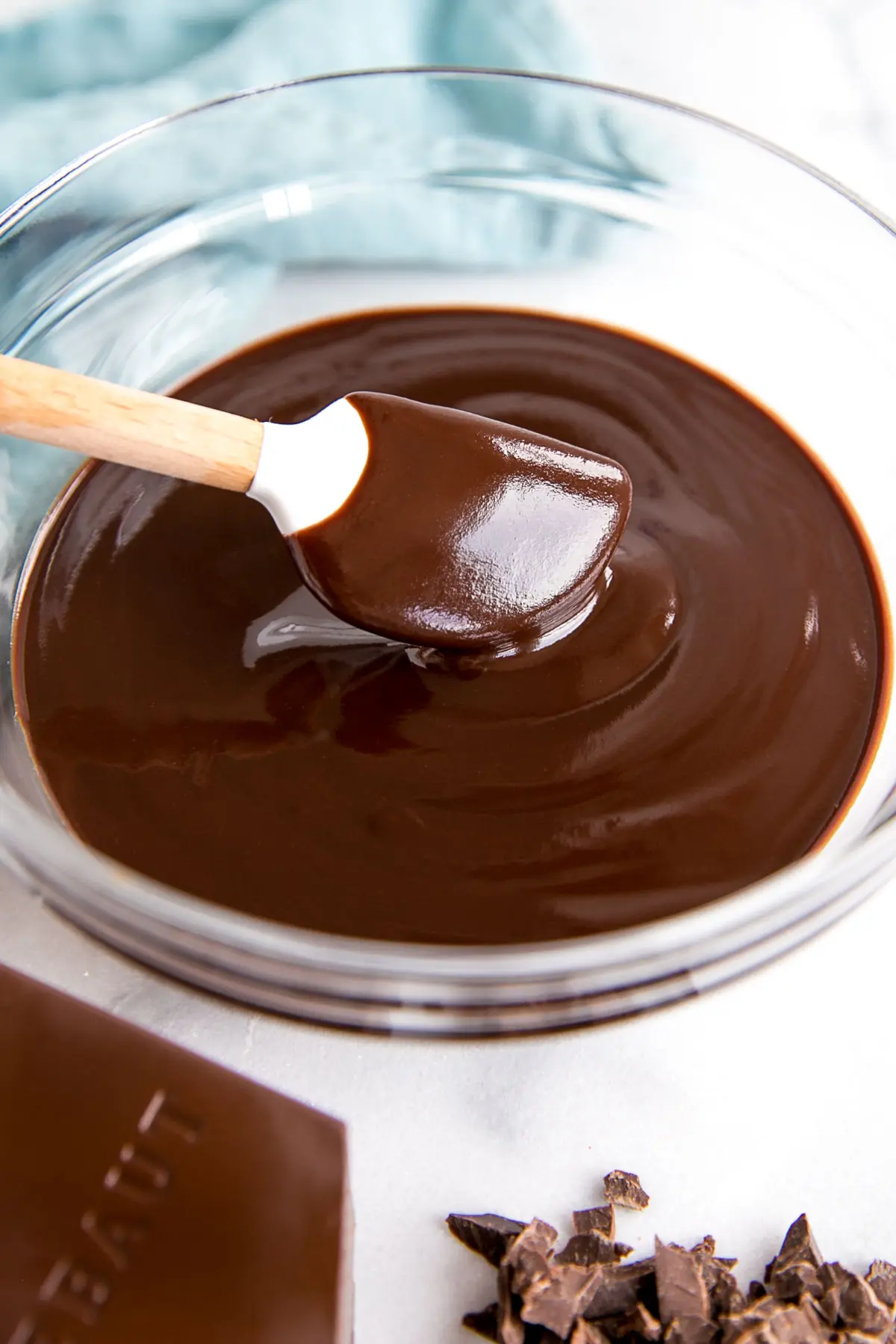 How to make Chocolate Ganache! A simple, two-ingredient recipe for a delicious frosting, filling, drip, or glaze. | livforcake.com Dark chocolate ganache in a bowl with a white spatula.
