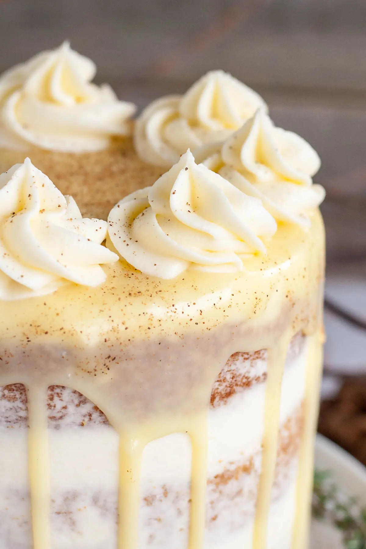 This Eggnog Cake with cream cheese frosting and white chocolate ganache is just the thing to warm you up this Holiday season! | livforcake.com Close up of rosettes on an eggnog cake.