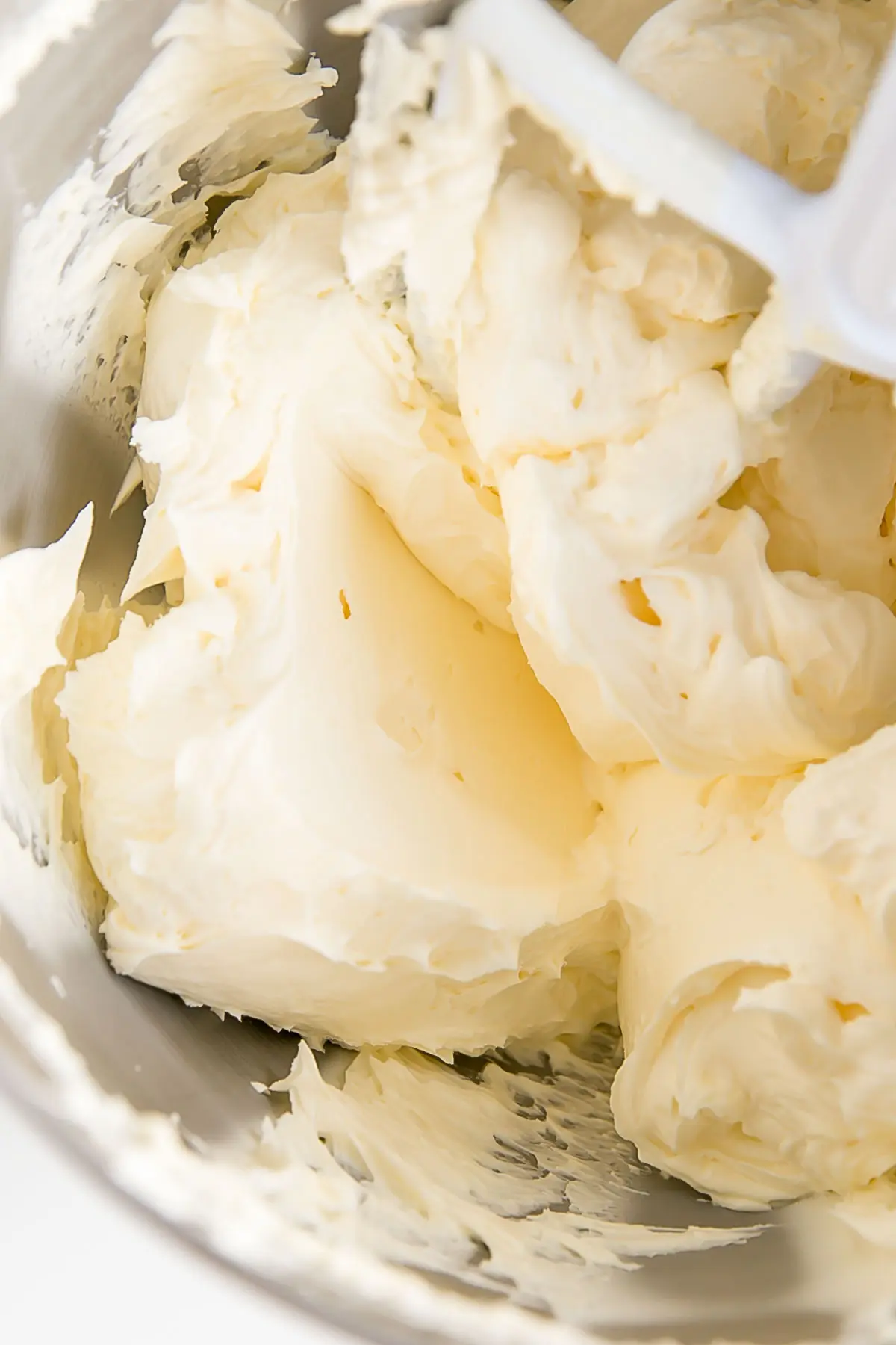 This custard-based German buttercream is made with just a few simple ingredients. Perfect for those who like a rich and silky frosting that isn't too sweet! | livforcake.com German buttercream fluffy and smooth in a stand mixer bowl.