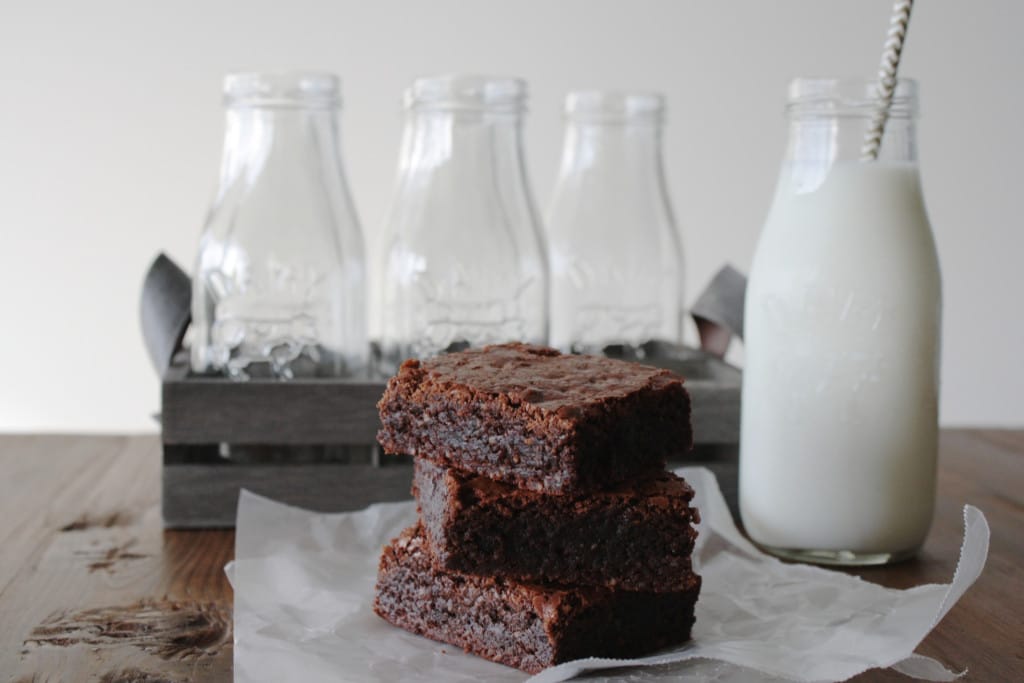 Stack of brownies with a glass of milk.