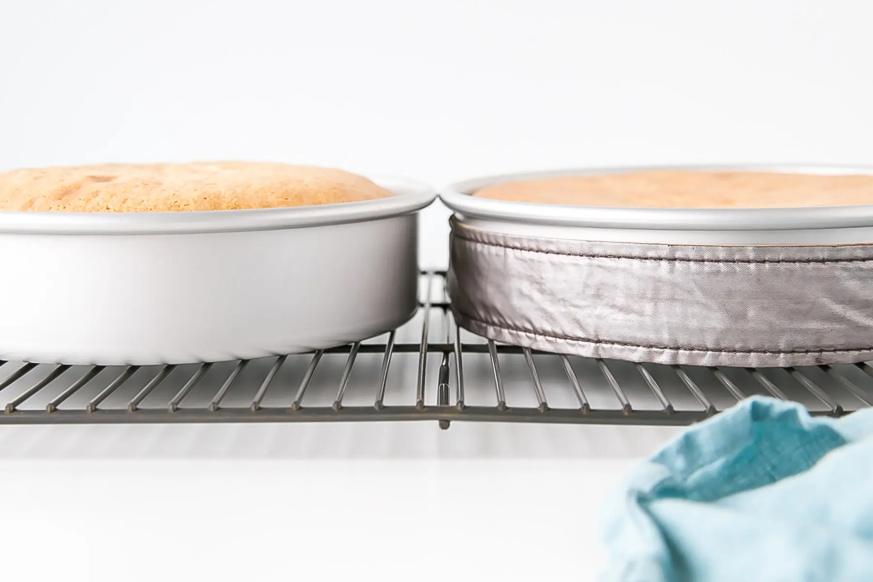 Learn how to bake flat cakes every single time! A simple tutorial on how to make sure your cakes come out nice and flat straight out of the oven. | livforcake.com Angled shot of the cakes in the pans