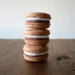 Stack of macarons on a wooden table.