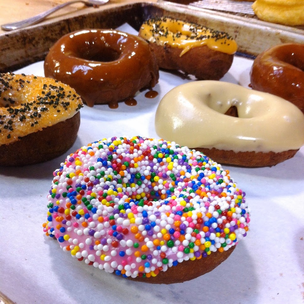 A close up of a doughnut covered with different toppings sitting on a table