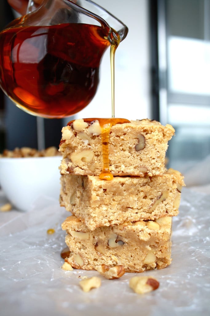 Stack of maple bars with maple syrup being drizzled on top.