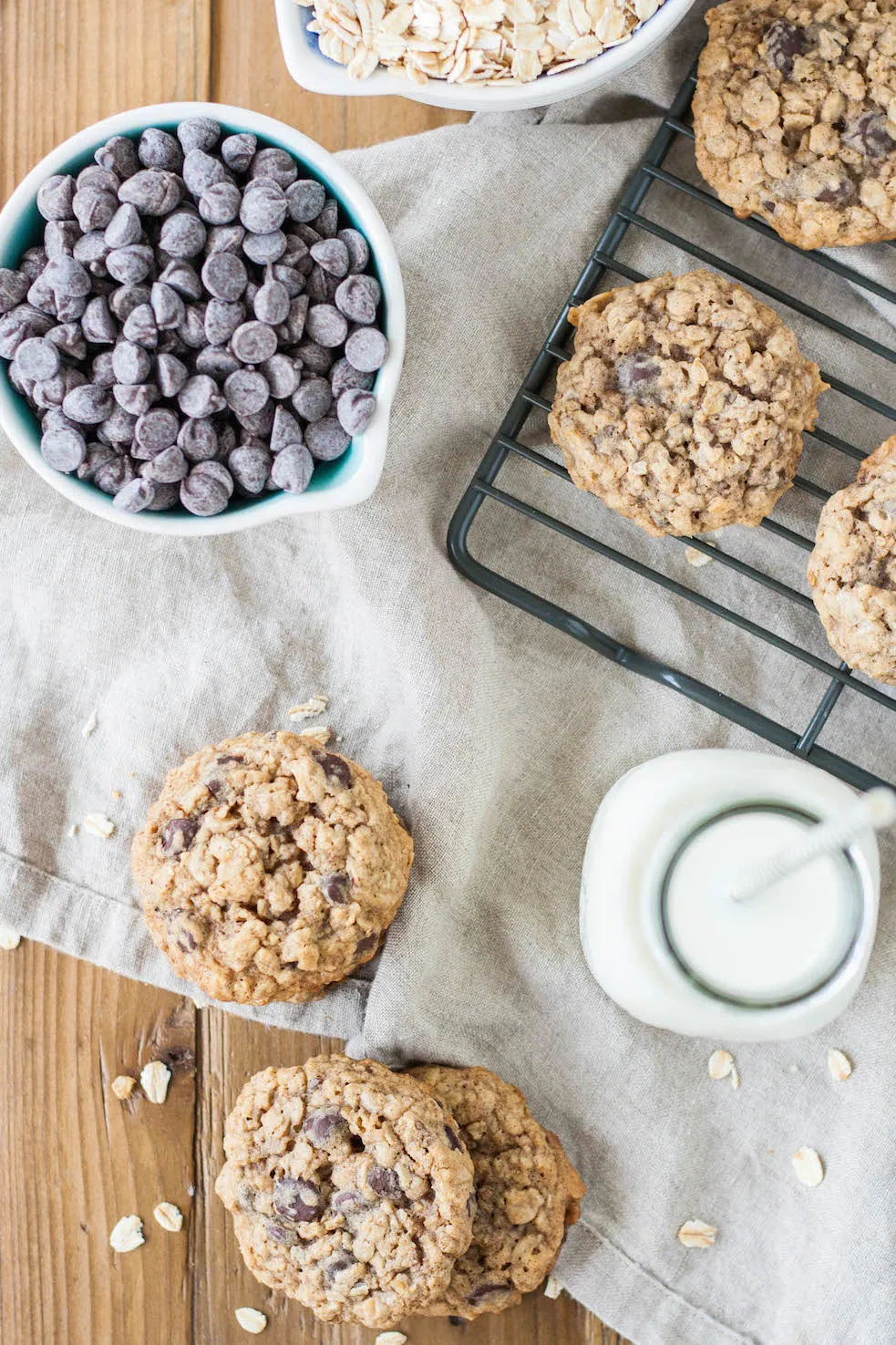 The BEST soft and chewy oatmeal chocolate chip cookies. | livforcake.com Chewy aatmeal chocolate chip cookies top down with chocolate chips and milk.