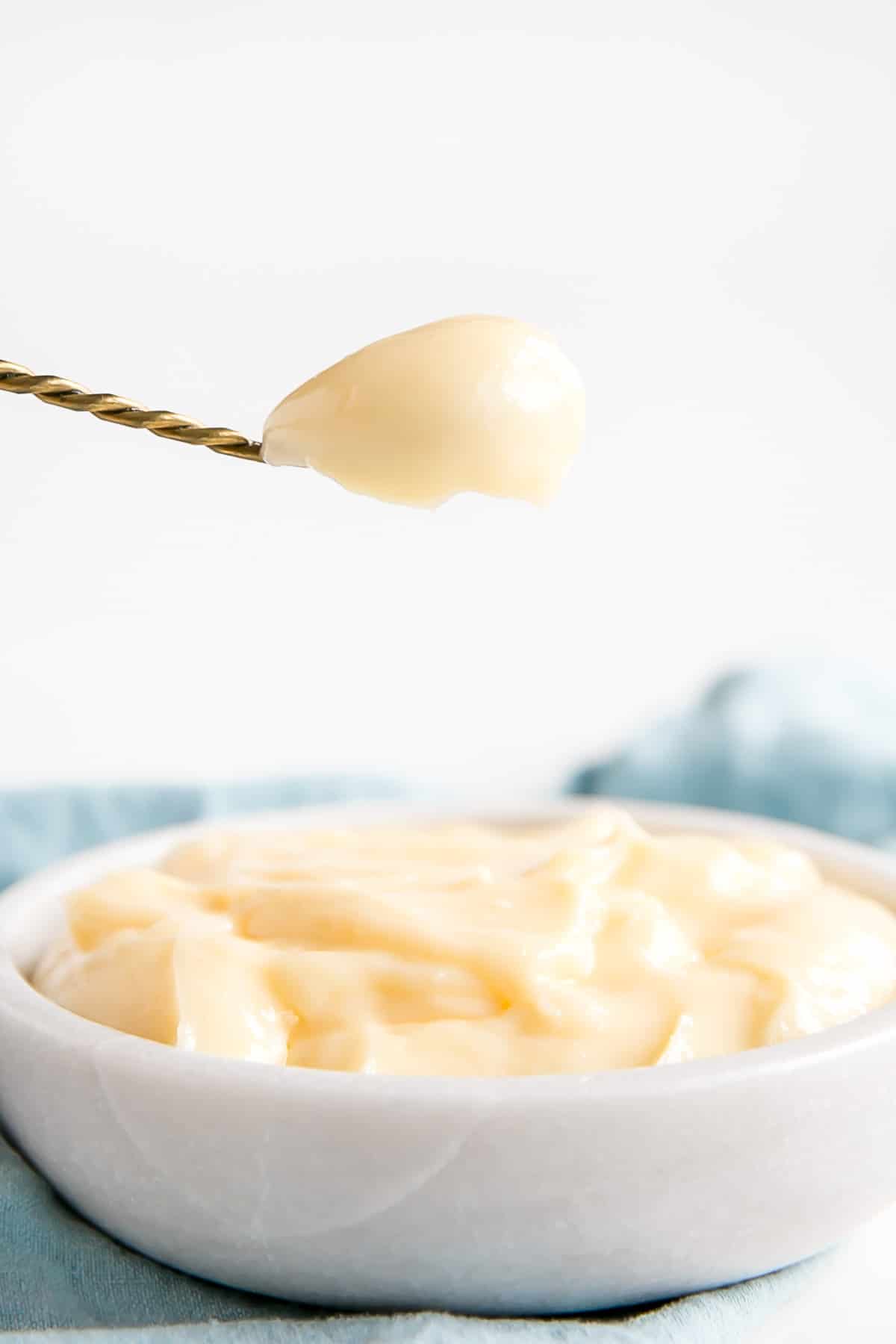 This easy Pastry Cream (Creme Patissiere) recipe is simple and delicious. A rich and creamy vanilla custard you can use in a variety of decadent desserts. | livforcake.com Spoonful of creme patissiere close up.