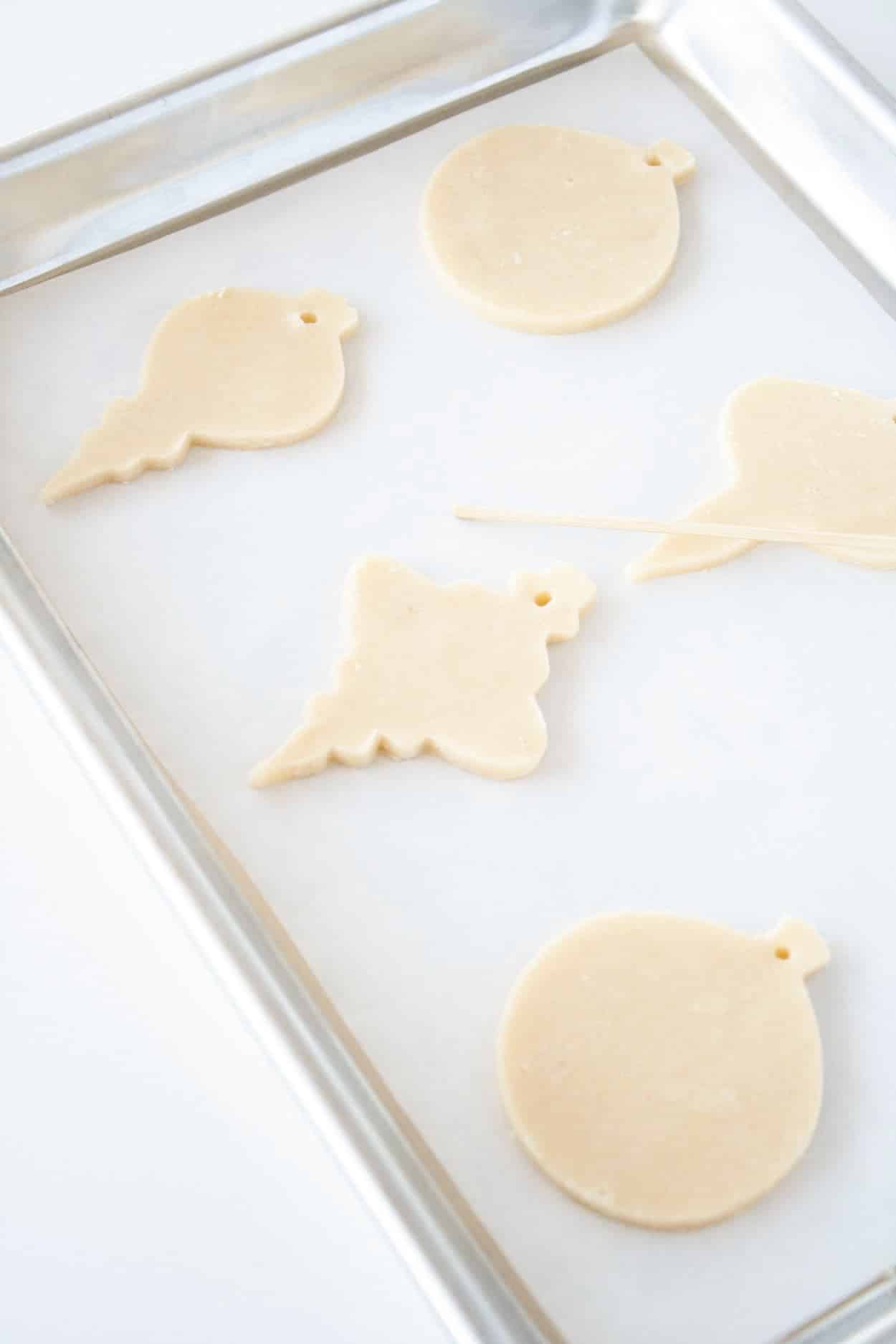 Learn how to make stunning stained glass cookies with this detailed tutorial! Perfect for holiday cookie exchanges or hanging on your tree. | livforcake.com Cut out cookies on a baking sheet