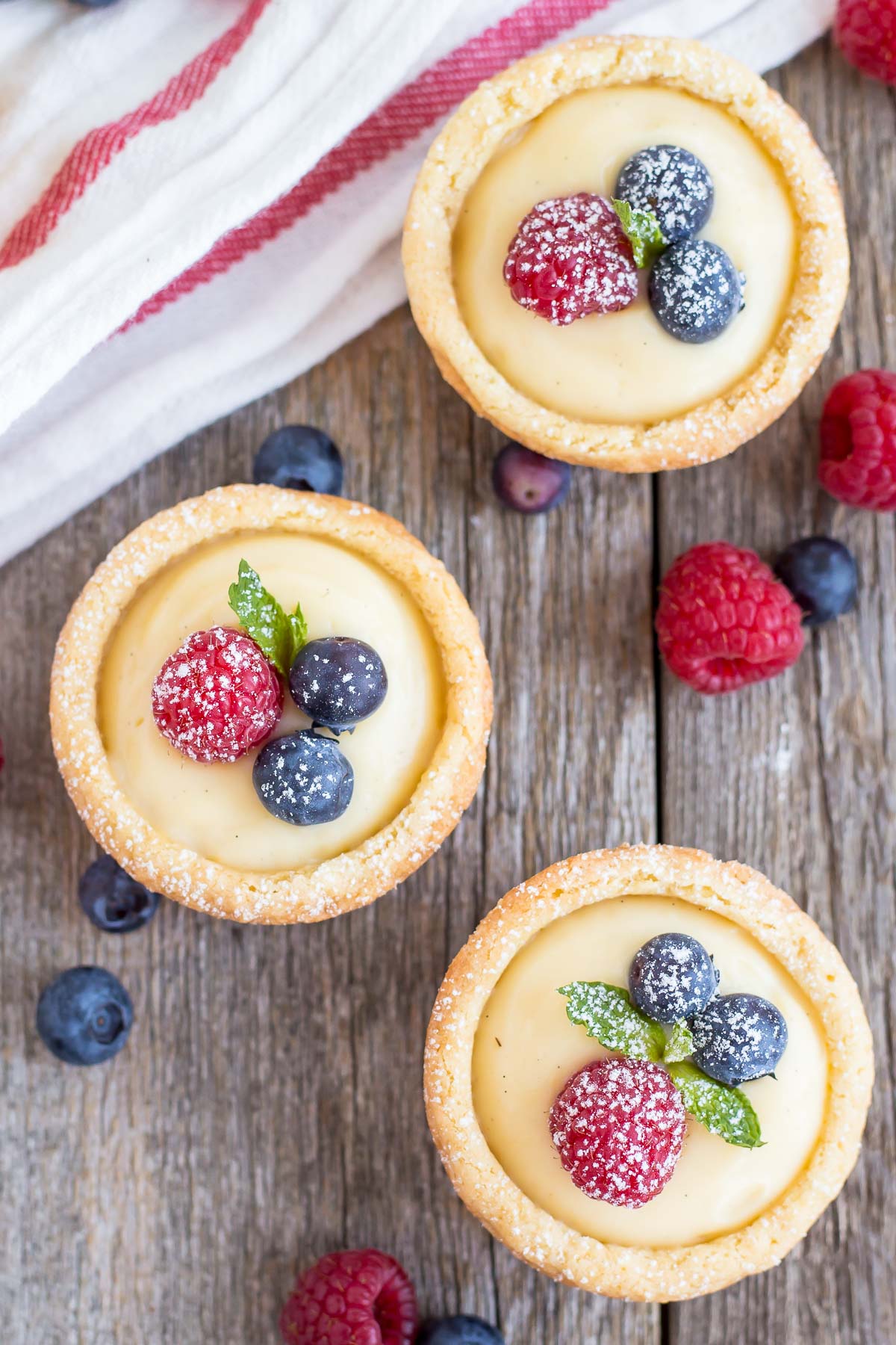 Vanilla Custard Cookie Cups! Bite-sized sugar cookie cups filled with a creamy vanilla custard and topped with fresh berries. | livforcake.com Vanilla Custard Cookie Cups top down shot