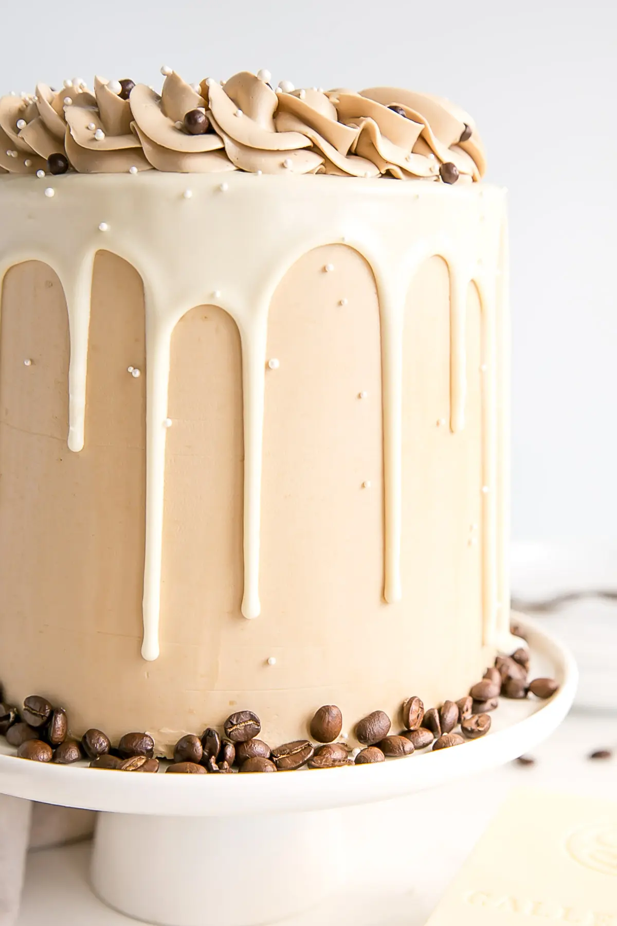 Close up of the side of the cake showing the frosting and the white chocolate ganache drip.